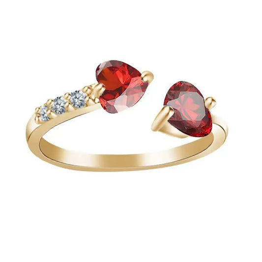 Goldfarbener Ring mit Herzsymbol in Rot und schmalem Steg auf weißem Hintergrund
