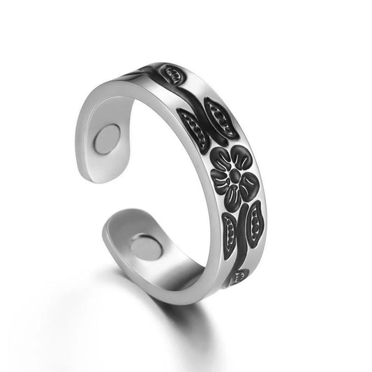 Moderner Ring in der Farbe Silber und schwarzer Gravur mit Magnete auf weißem Hintergrund